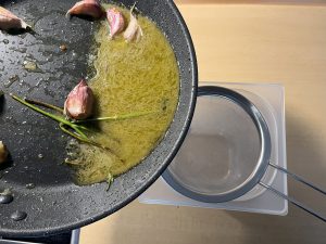 Bild zeigt das abseihen von Olivenöl für die Spaghetti alle Vongole.